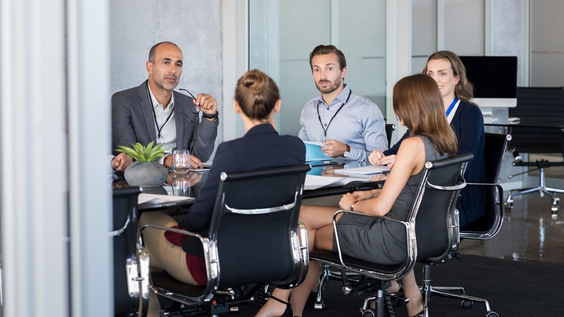 Group of business professionals sitting around a conference table working together